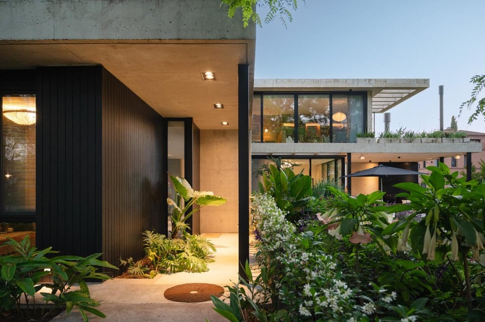 Patio con arquitectura moderna y jardín al atardecer