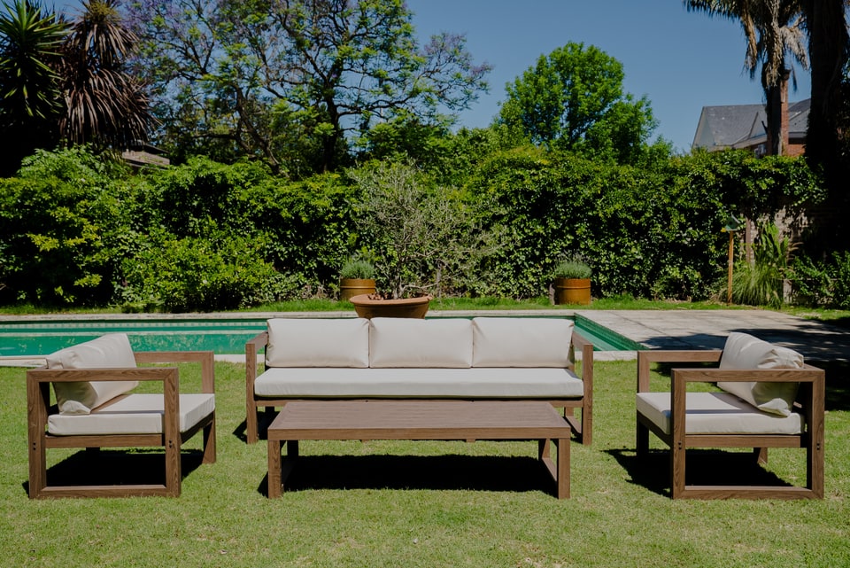 Conjunto de muebles de exterior con tapizado náutico claro junto a la pileta — Velenza