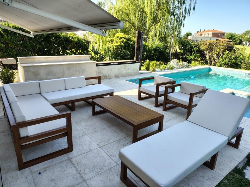 Conjunto de muebles de exterior con camastro y tapizado náutico junto a la pileta — Velenza