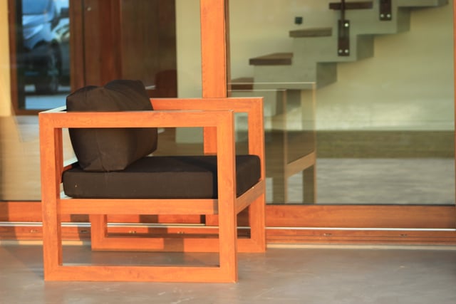 Sillón con almohadones en tela para exterior frente a vidriado — Velenza