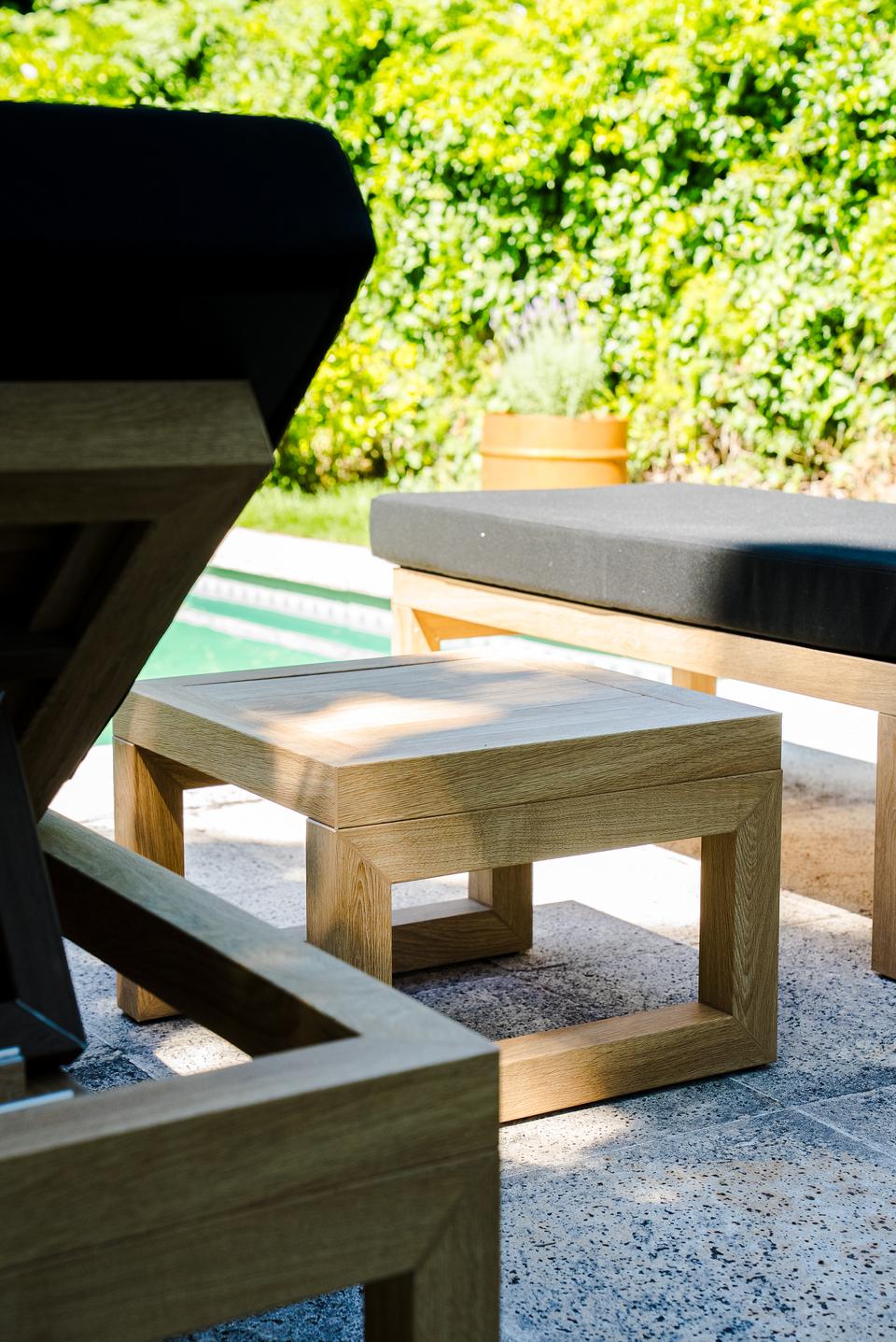 Detalle de mesa de apoyo y reposeras Velenza junto a pileta